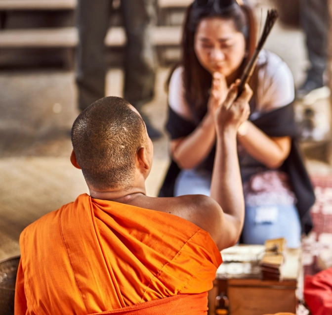 Lady praying in front of a monk&nbsp;