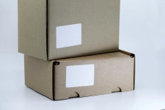 two stacked brown cardboard box with white labels
