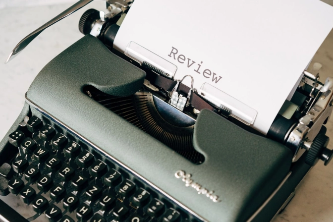 Black typewriter with inserted white paper on a table