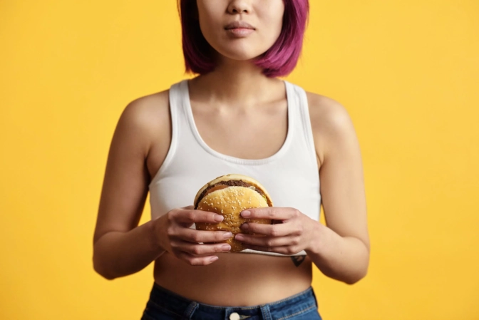 Woman holding on to a hamburger&nbsp;