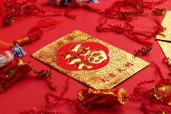 single red and gold hong bao in the middle of tiny red lanterns on red background